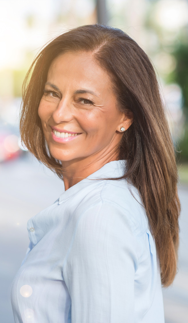 Beautiful middle age hispanic woman at the city street on a sunny day with a happy face standing and smiling with a confident smile showing teeth