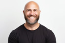 Portrait of a happy bald man in a black t-shirt with crossed arms