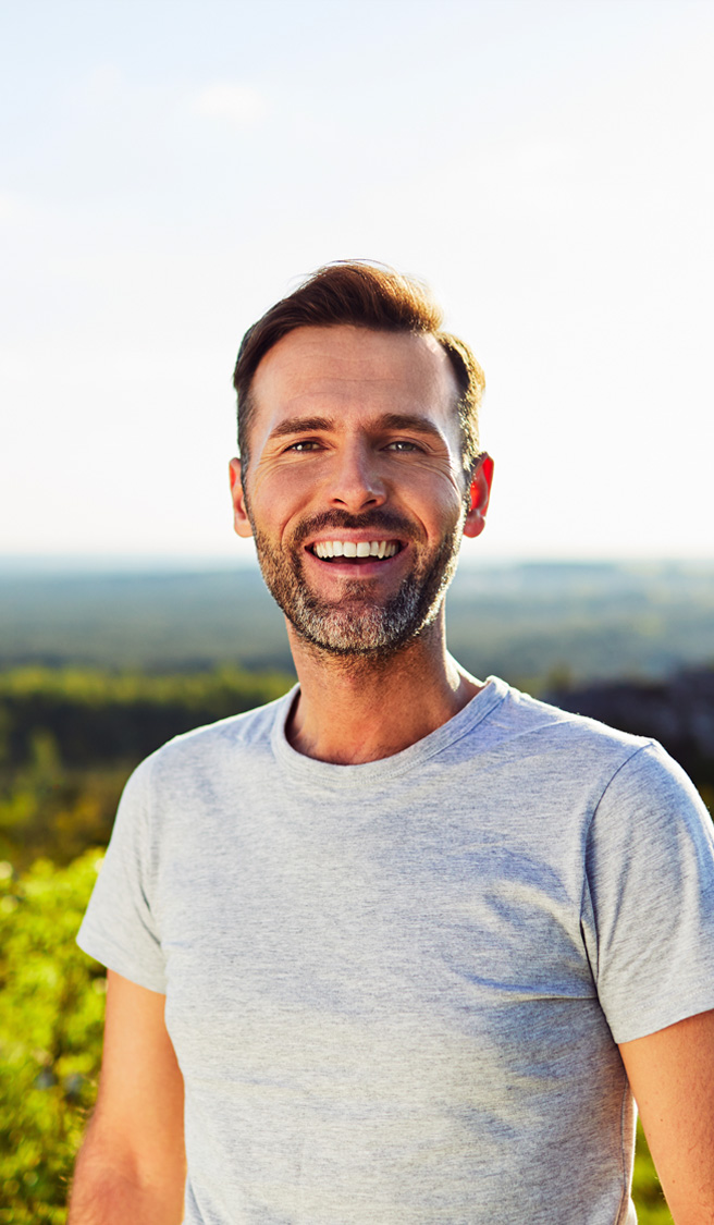 Portrait of happy adult man smiling outdoors
